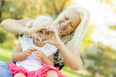 Little Girl With Mother Making Heart Shape with Hands