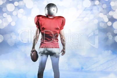 Composite image of rear view of american football player with ba