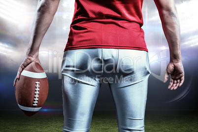 Composite image of mid section of sportsman with american footba