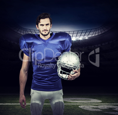 Composite image of american football player holding an helmet