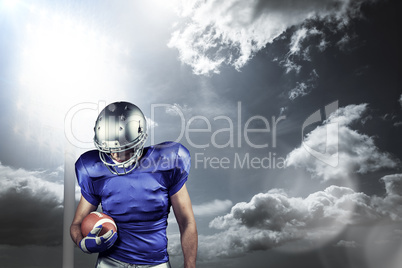 Composite image of american football player looking down while h
