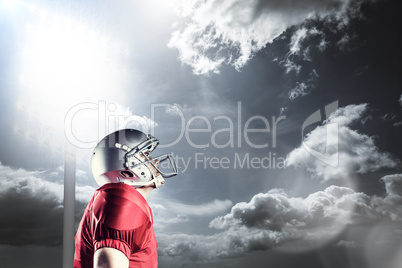 Composite image of american football player looking up while sta