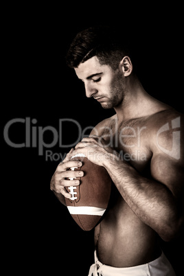 Composite image of shirtless rugby player holding the ball