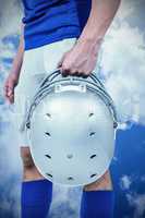 Composite image of sports player handing his helmet