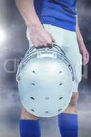 Composite image of sports player handing his helmet