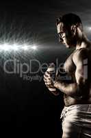 Composite image of shirtless american football player with ball