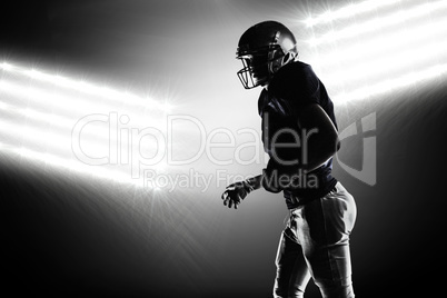 Composite image of silhouette american football player walking