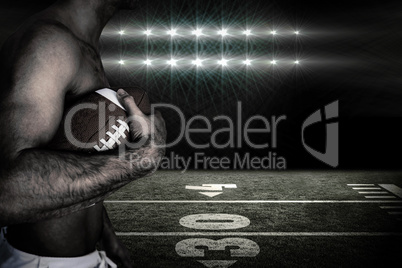 Composite image of side view of shirtless rugby player holding b