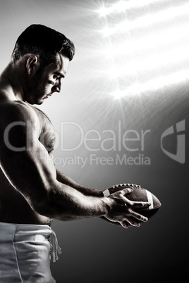 Composite image of shirtless american football player with ball