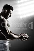 Composite image of shirtless american football player with ball