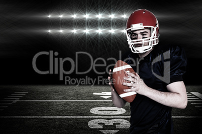 Composite image of serious american football player holding a ba