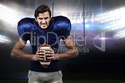 Composite image of aggressive american football player holding b