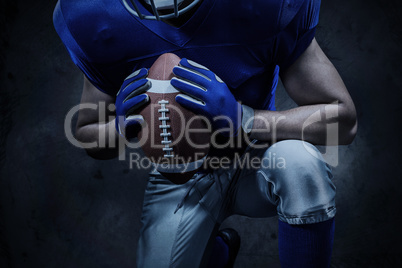 Composite image of mid section of american football player kneel