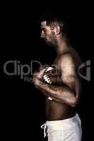 Composite image of side view of shirtless man holding ball