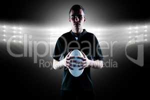 Composite image of rugby player holding a rugby ball