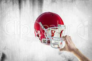 Composite image of american football player holding up his helme