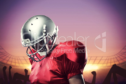 Composite image of american football player looking down