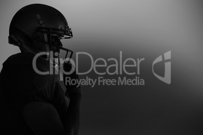 Side view of silhouette American football player wearing helmet