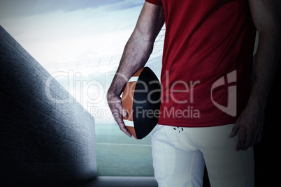 Composite image of midsection of a player holding rugby ball