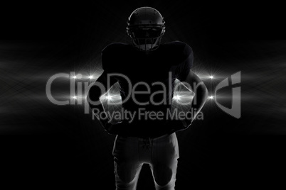 Composite image of silhouette american football player standing