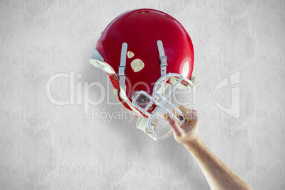 Composite image of american football player holding up his helme