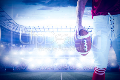 Composite image of american football player holding up football Composite image of american football player holding up football