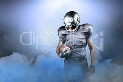 Composite image of american football player looking down while h