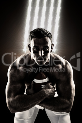 Composite image of shirtless american football player with ball