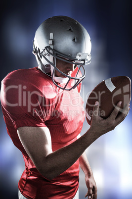 Composite image of sportsman looking at american football while