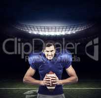 Composite image of aggressive american football player holding b