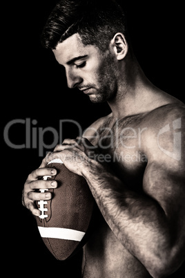 Composite image of rugby player holding the ball while looking d