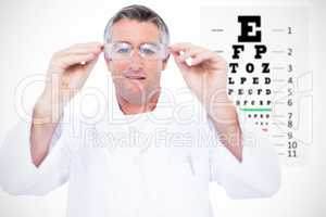 Composite image of optician in coat holding glasses