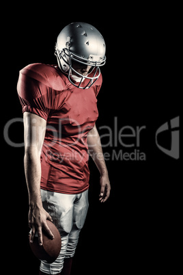 Composite image of american football player with ball looking do