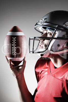 Composite image of sportsman looking up while holding american f