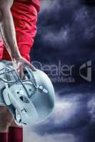 Composite image of american football player holding helmet