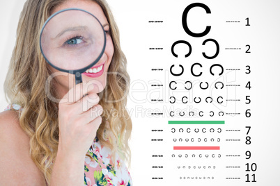 Composite image of smiling woman holding magnifying glass