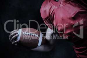 Composite image of cropped american football player holding ball