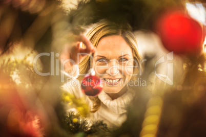 Festive blonde hanging bauble on christmas tree