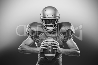 American football player in red jersey and helmet holding ball