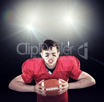 Composite image of american football player crushing a ball