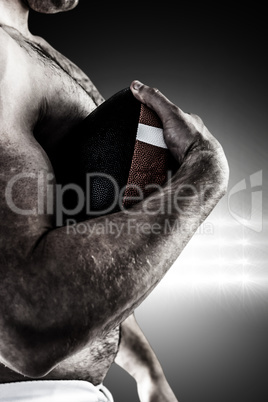 Composite image of shirtless american football player with ball