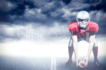 Composite image of american football player bending while holdin