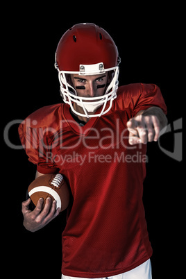 Composite image of portrait of rugby player pointing while holdi