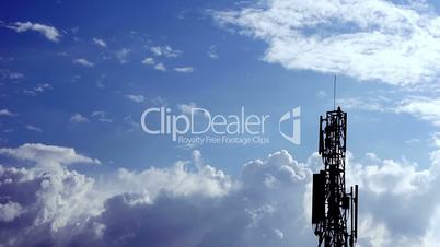 Clouds on hot blue sky with network tower, time lapse