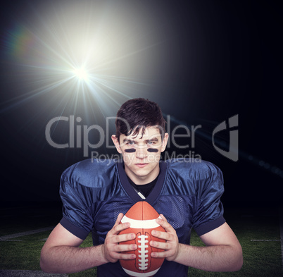 Composite image of determined american football player holding a