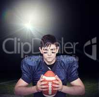 Composite image of determined american football player holding a