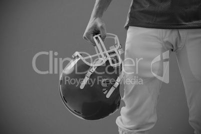 Composite image of an american football player taking his helmet