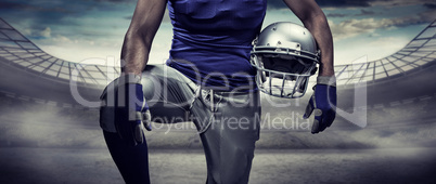 Composite image of mid section of sportsman holding helmet