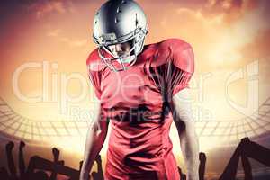 Composite image of american football player looking down while s