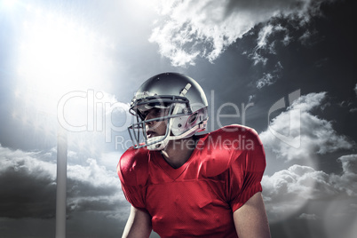 Composite image of sportsman holding american football while kne